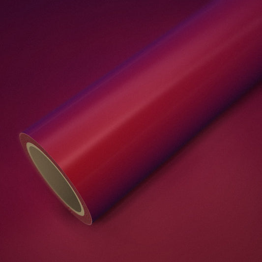 Rolo de vinil vermelho mágico (color flip) sobre uma folha do mesmo vinil