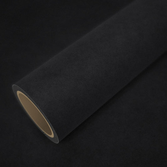 Rolo de vinil efeito alcantara preto sobre uma folha do mesmo vinil